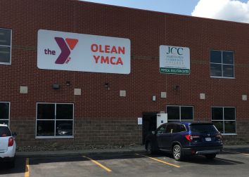 A photo of a brick building with signs that head Olean YMCA and Jamestown Community College.