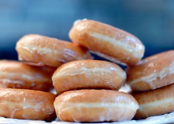 Small stacks of glazed donuts on a plate.