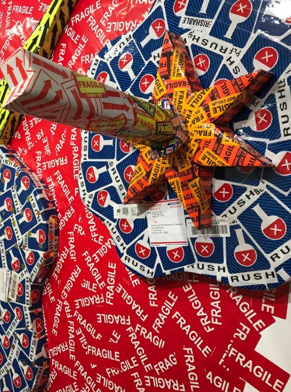 Colorful star-shaped package wrapped in overlapping “fragile” and “rush” tape. The background features a chaotic mix of the same tapes.