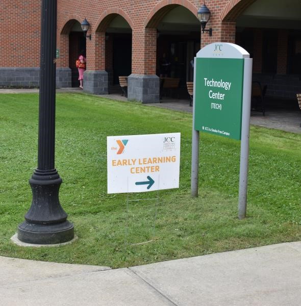 A lawn sign on campus pointing the way to the JCC YMCA Early Learning Center